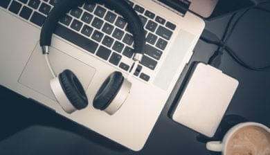 Image représentant un ordinateur et un casque audio pour le transcrition de l'audio en texte